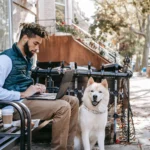 A man enjoys a mindful work break with his loyal dog by his side on a city bench, illustrating the balance of productivity and minimalist urban living